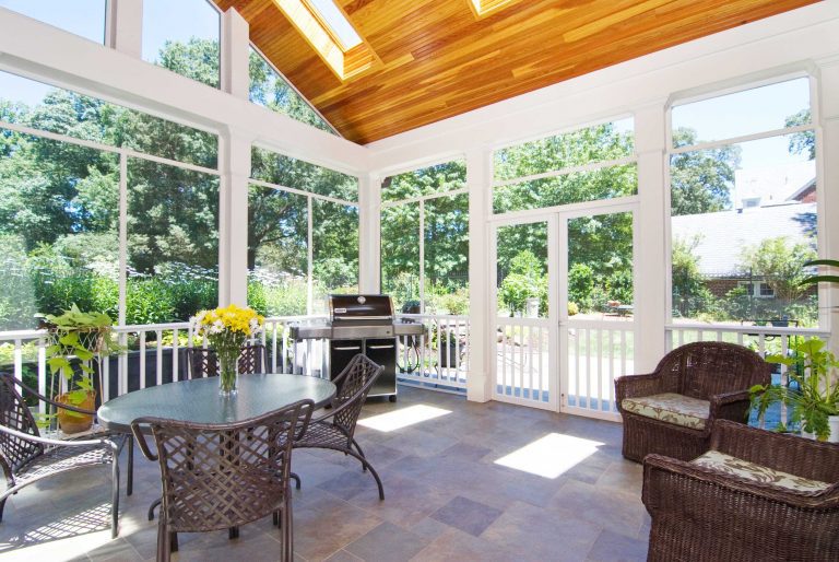 screened in back porch with vaulted wood ceiling skylights and stone floors