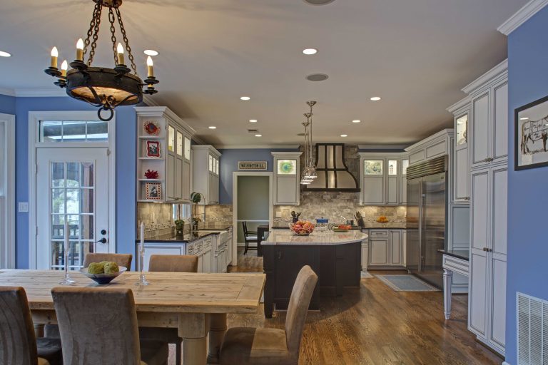 neutral colored renovated kitchen flows into dining room with blue walls