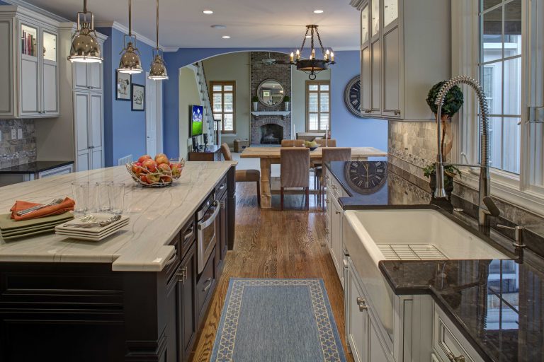 view into dining and living rooms from renovated kitchen traditional style pendant lighting over island