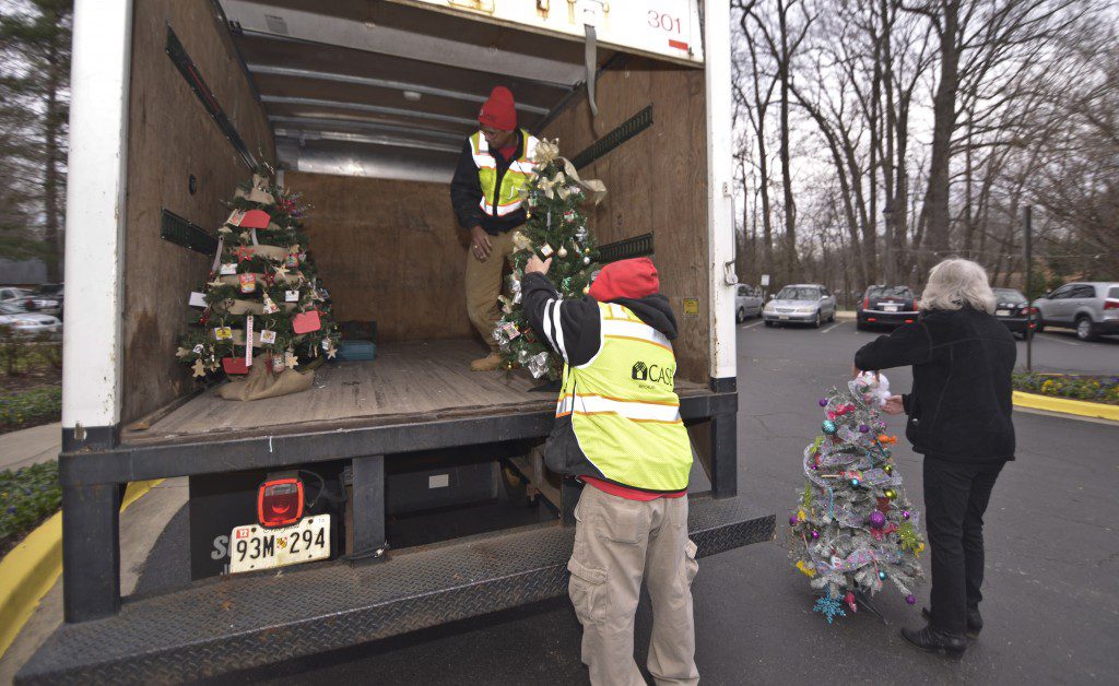 The team carefully unloads the decorated holiday trees