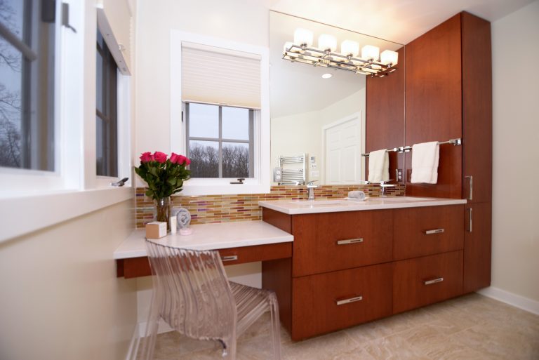 modern vanity area in renovated bathroom dark cabinetry plenty of storage mosaic tiling