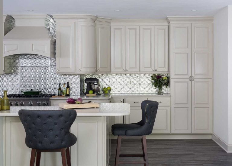 traditional kitchen white cabinetry gray wood floors island seating stainless steel statement backsplash