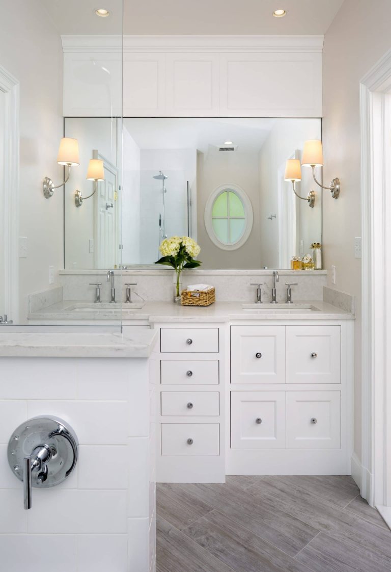 bathroom beige color palette double sink vanity with white cabinetry and sconce lighting