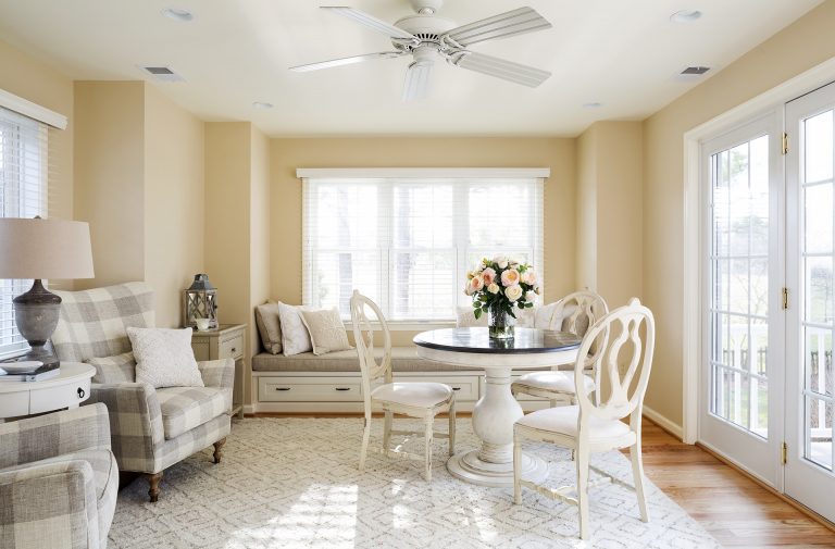 bright living area large window yellow color palette window seat and french doors