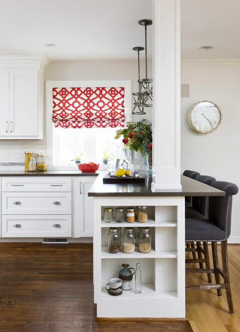 open shelving storage built into side cabinetry peninsula with seating wood floors