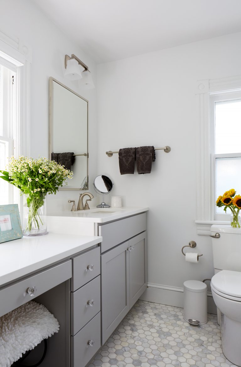 renovated bathroom vanity with gray cabinetry and built in makeup area