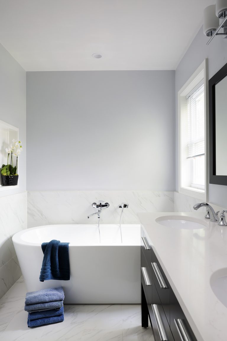 freestanding bathtub with wall mounted fixtures half wall tiling nook built into wall