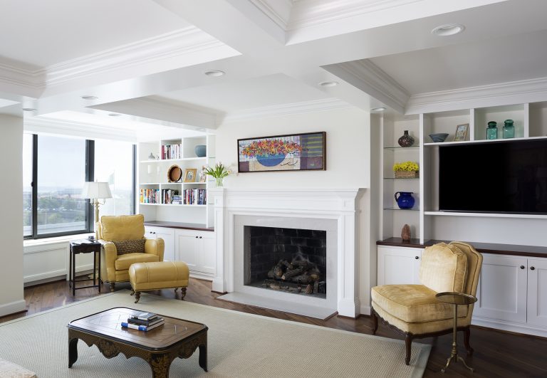 bright living room with wood floors coffered ceiling fireplace built in bookcases recessed lighting