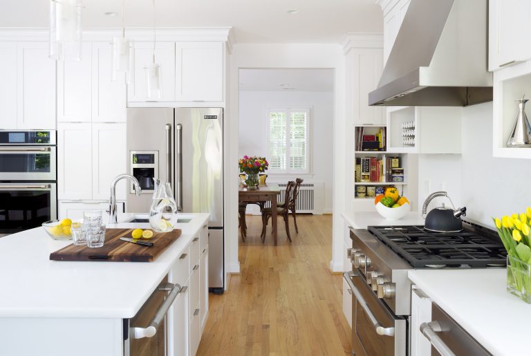 side view of kitchen into formal dining room white cabinetry stainless steel appliances