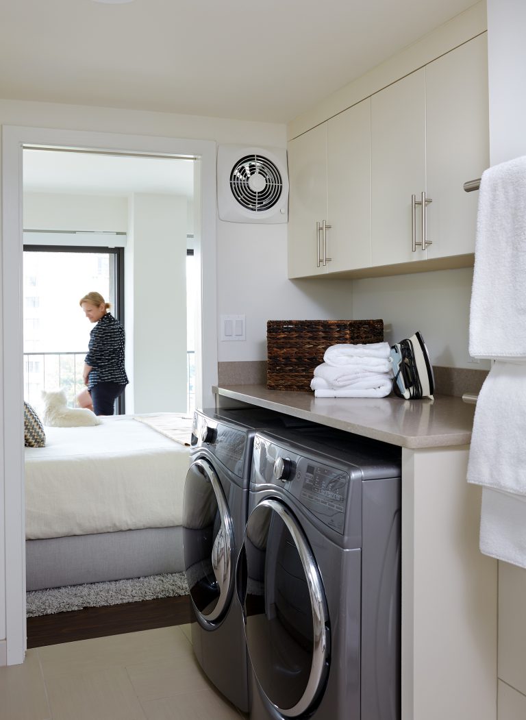 laundry room off of master bedroom plenty of storage white cabinetry