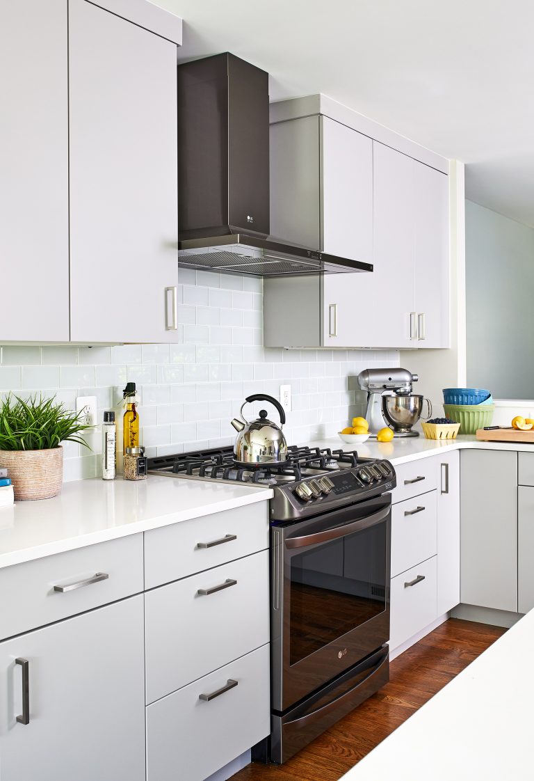 kitchen with white cabinetry dark wood floors dark stainless steel gas range and hood