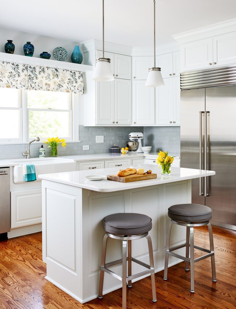 white kitchen with island seating and pendant lighting open display shelf above window