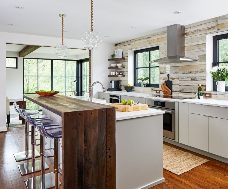 eclectic kitchen with two tiered island with bar height seating and wood waterfall edge counter feature tile backsplash