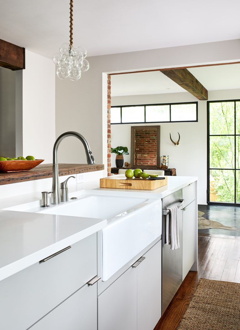 sleek kitchen with gray cabinetry and porcelain apron sink in island wood floors brushed chrome fixtures and hardware