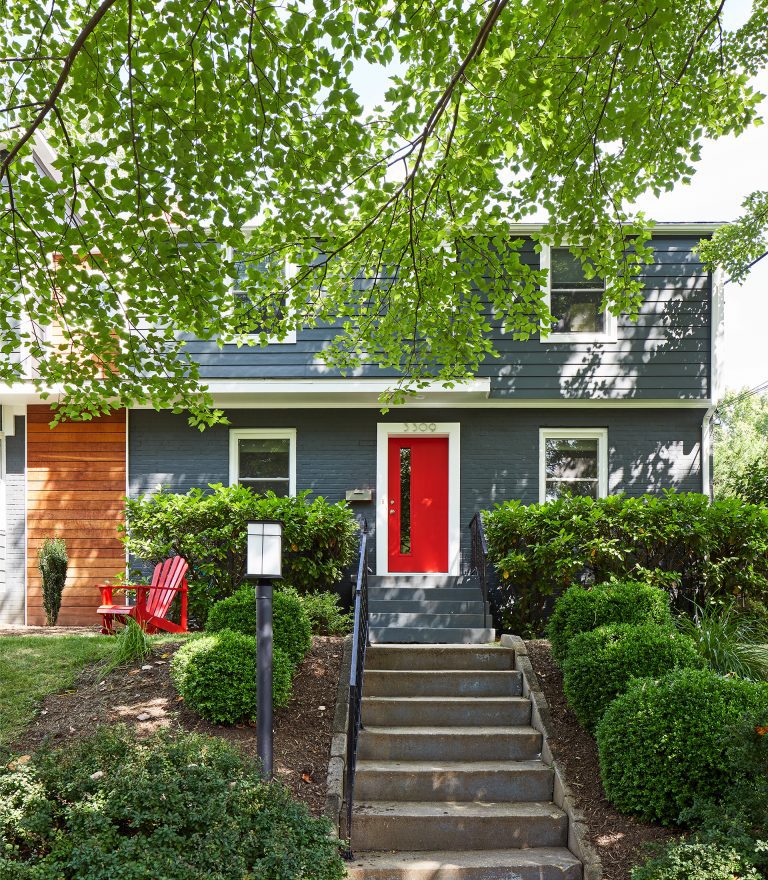 blue house with red door and wood panel detail modern design