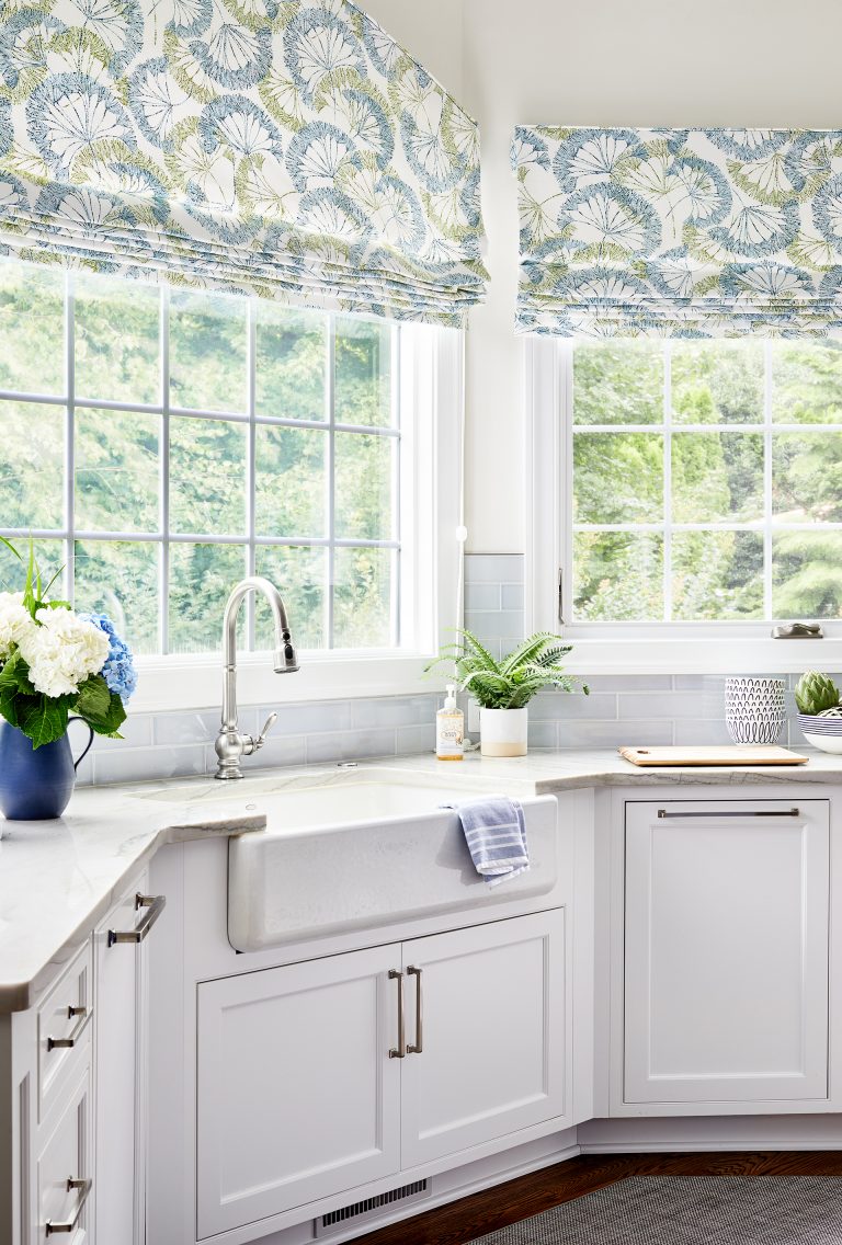kitchen bay window with white farmhouse sink and blue, yellow white shades
