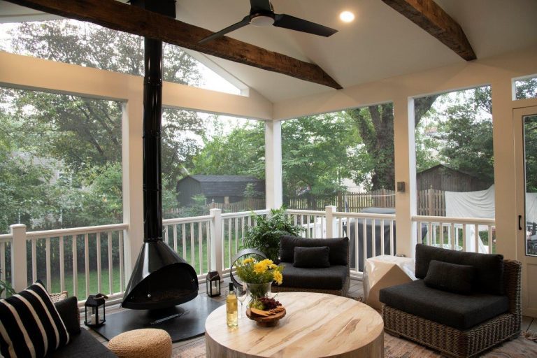 large patio with rusty wood beam, outdoor ceiling fan, wooden round table, fireplace