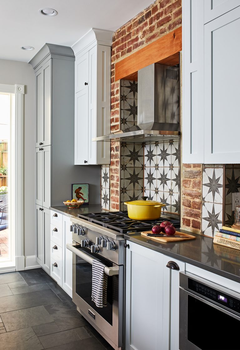 kitchen remodeling dc cabinets with round black knobs, slate flooring, gas range stove and star backsplash