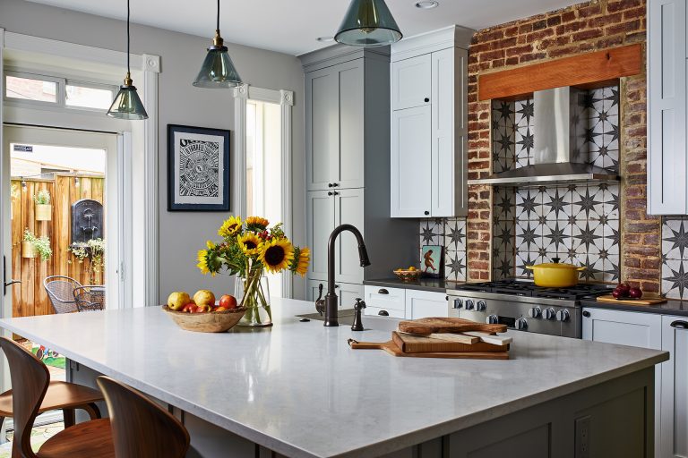 dc design kitchen island with sink and seating with white cabinets with round black knobs