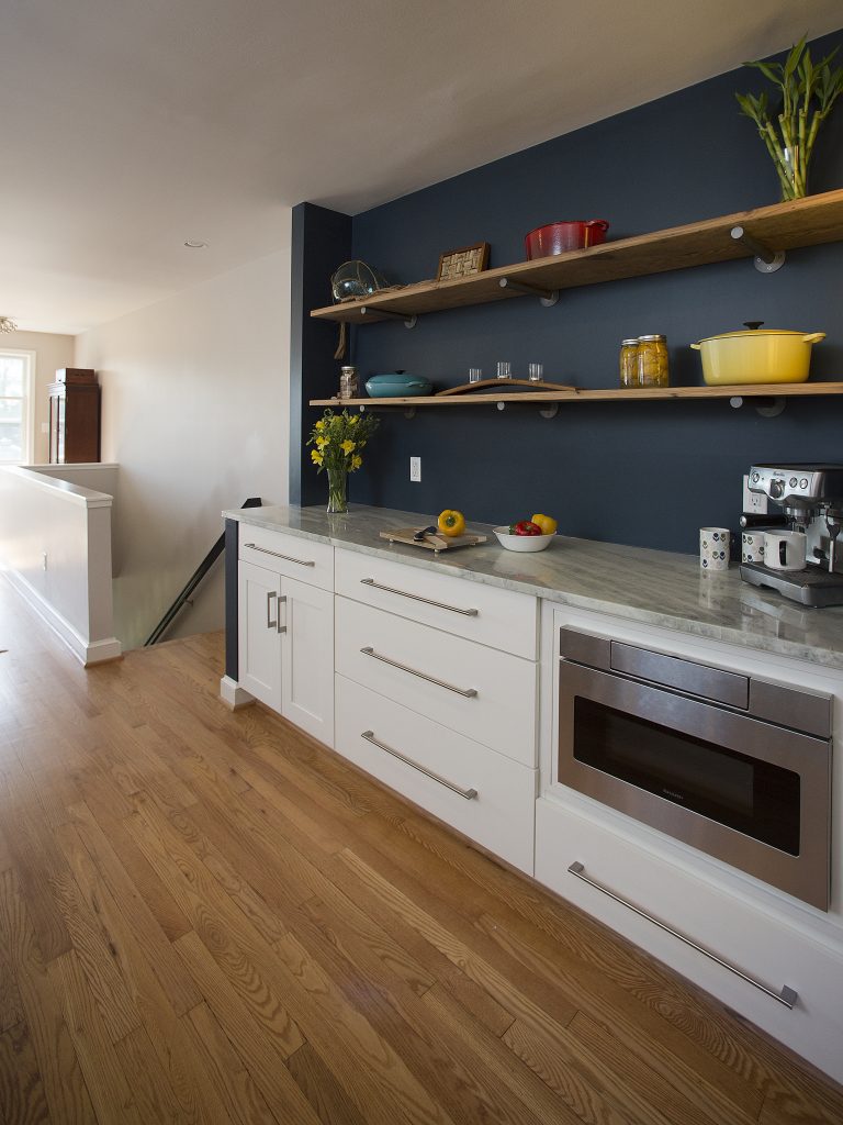 kitchen with navy walls white cabinetry open shelving stainless steel appliances