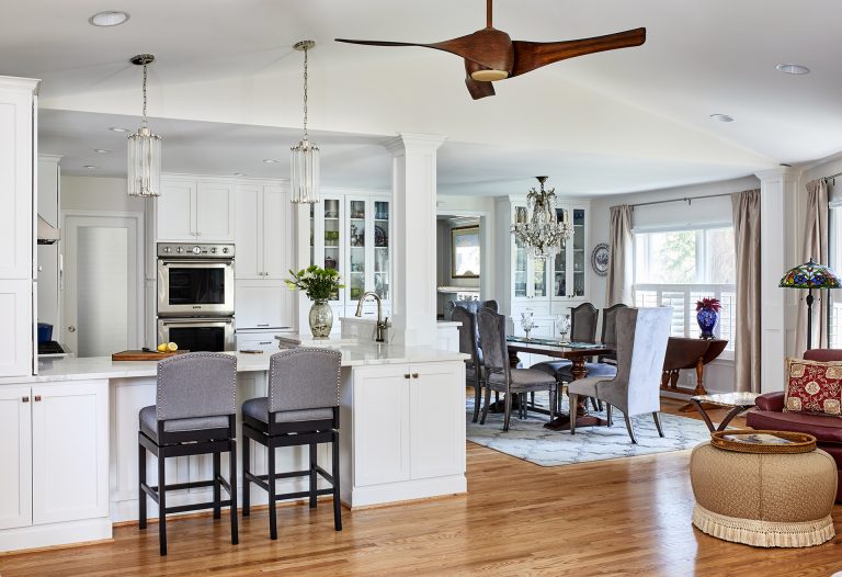 transitional style open kitchen open to the dining room and living room, wooded flooring high vaulted ceiling with a wooded ceiling fan