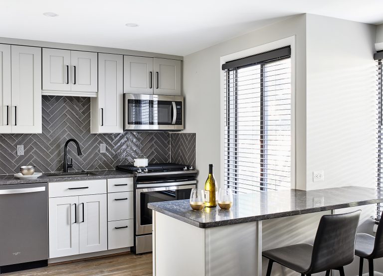 transitional gourmet white and grey kitchen with subway grey backsplash, black faucet