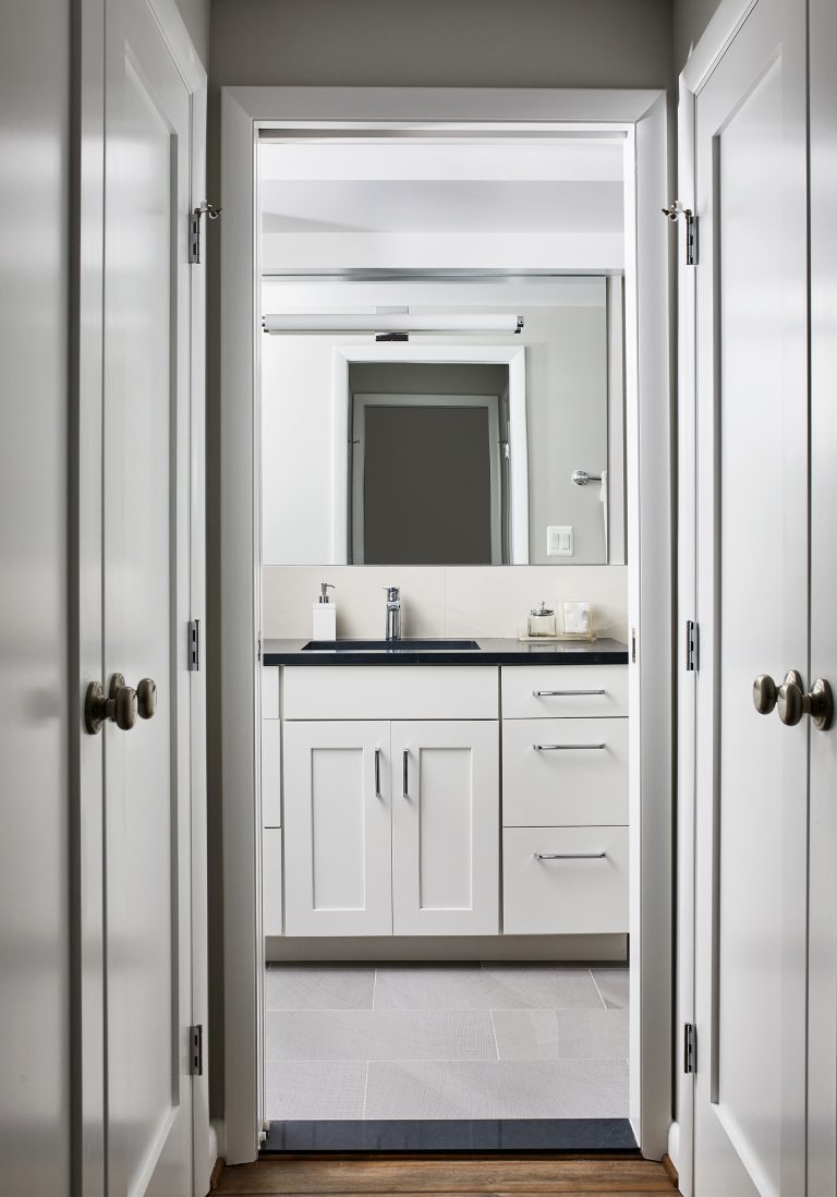 large square glass wall mirror above large vanity.