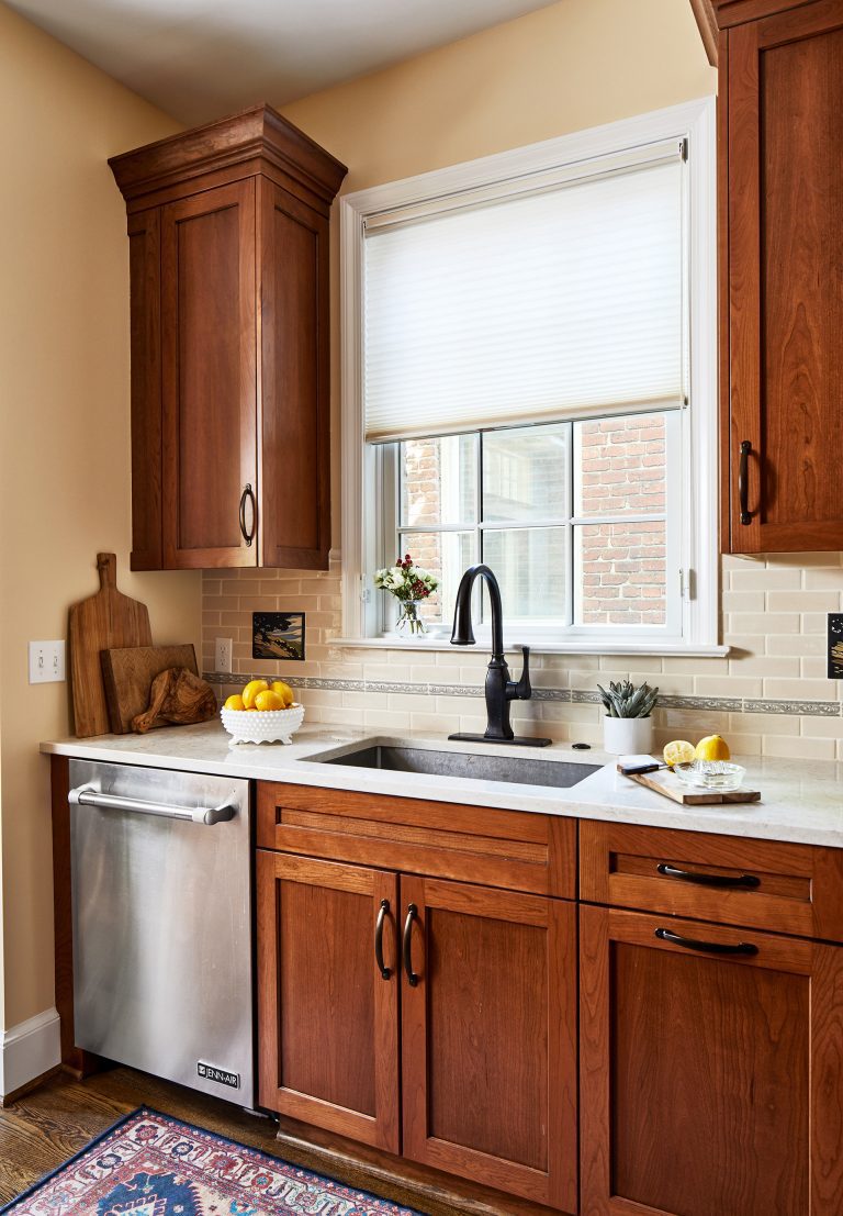 tall wood floating kitchen cabinets with farmhouse sink and window view, stainless steel dishwasher